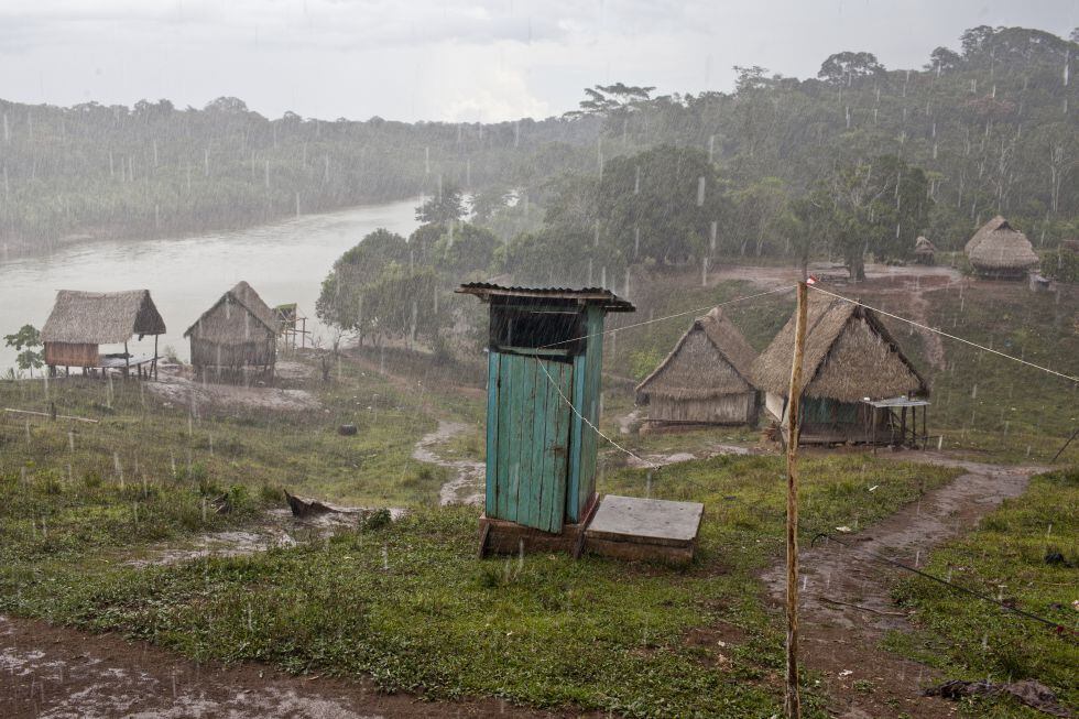 Una fuerte lluvia cae sobre las casas de una comunidad indígena junto al río Purus en Ucayali (Perú).