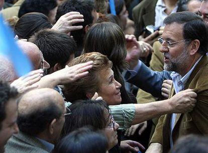 Varios simpatizantes intentan tocar a Mariano Rajoy en el mitin del Partido Popular en Zaragoza.