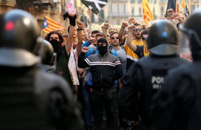 Manifestantes independentistas protestas frente a agentes de los Mossos d'Esquadra para impedir la marcha de la asociación de policías y guardias civiles.