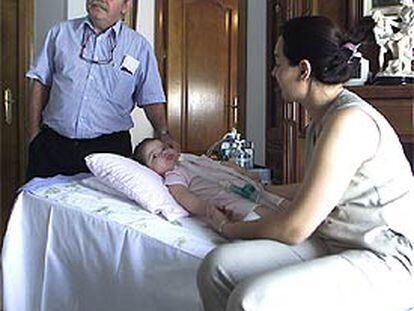 La niña María Domínguez rodeada del doctor José Luis Royo y su madre, Dori García.
