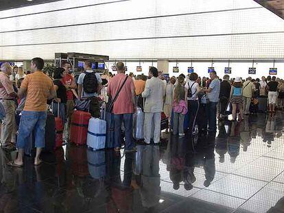 Viajeros haciendo cola ayer en la terminal B del aeropuerto de El Prat (Barcelona).