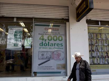 Un hombre camina junto a un negocio de envío y recepción de dinero, en Ciudad de México, en una imagen de archivo.
