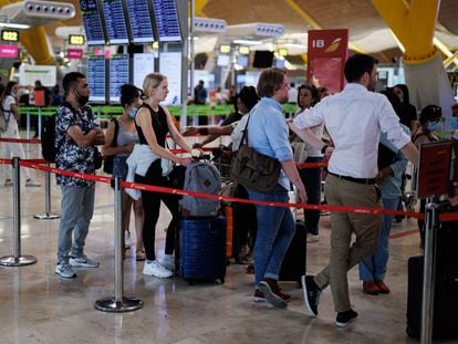 Varias personas con maletas hacen cola en la Terminal 4 (T4) del aeropuerto Adolfo Suárez Madrid-Barajas.