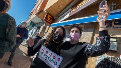 Noelia Garnés (derecha), trabajadora de la administración de lotería de la pedanía murciana de Sangonera la Seca, celebra con una clienta tras vender números del 44.469, agraciado con el segundo premio.