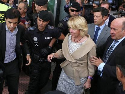 Guti&eacute;rrez Moliner, a la derecha, ayuda a Aguirre a entrar en el coche tras declarar ante el juez