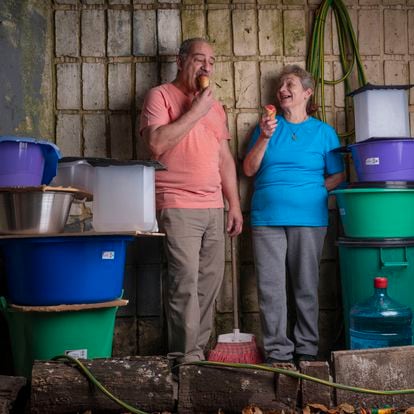 Arturo y Jorgelina Mema en el patio de su edificio.
Arturo trabaja como encargado en un condominio en Buenos Aires. Cada verano almacena agua por si se corta la luz. "Hace unos años empezamos a tapar los recipientes de agua, es nuestra nueva realidad como comunidad". 