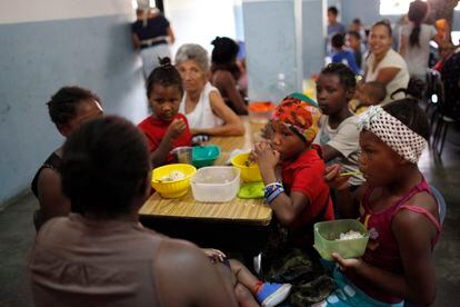 Un grupo de niños recibe alimentos en una cocina comunitaria financiada por una ONG, en Caracas (Venezuela).