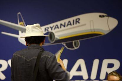 Un pasajero, ante un cartel de Ryanair.