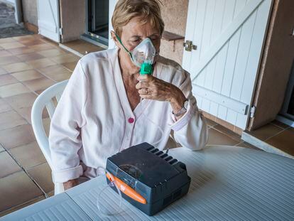 Una mujer con asma utiliza un nebulizador.