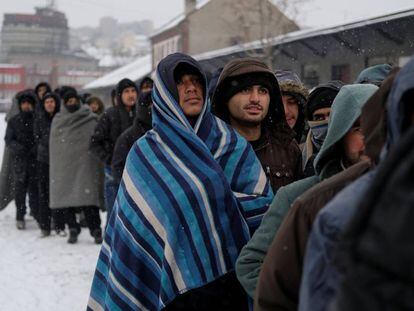 Refugiados esperan un plato de comida en un almac&eacute;n aduanero en Belgrado (Serbia).