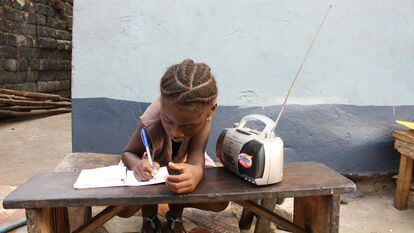 Angela Kamara, de seis años, estudia con ayuda de las clases que está escuchando por radio.