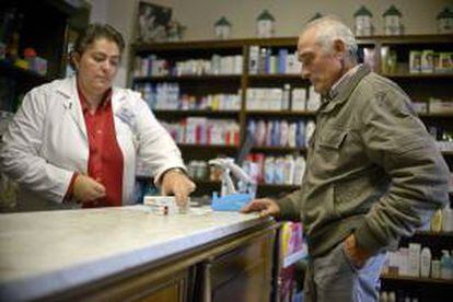 Un farmaceútico atiende a un cliente en su farmacia. EFE/Archivo