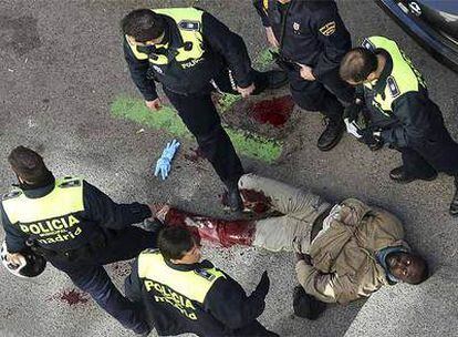 El hombre que huía, herido y tendido en el suelo, rodeado de agentes de la Policía Nacional en la calle Jacometrezzo.