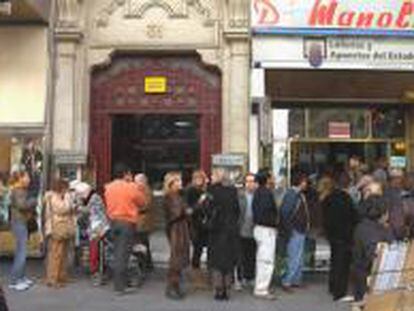 Un grupo de personas esperan su turno para comprar lotería de Navidad de Doña Manolita, en Madrid.