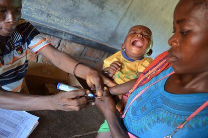 Un niño llora mientras le pintan la punta del dedo para indicar que ha sido vacunado en Lanome, Bangassou (República Centroafricana). 