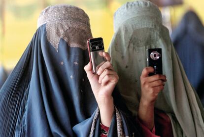 Mujeres afganas con burka utilizando modernísimos móviles con cámara