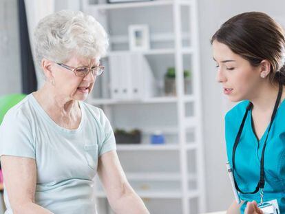 Una señora mayor es atendida en una consulta médica.