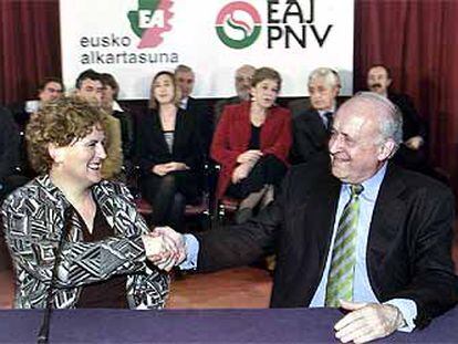 Begoña Errazti, presidenta de EA, estrecha la mano del líder del PNV, Xabier Arzalluz, tras firmar el pacto.