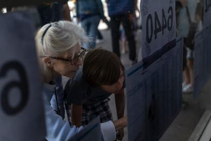 Una mujer busca su mesa de votación en un centro de votación de Buenos Aires.