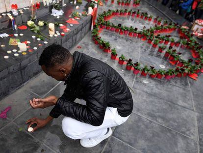 Un hombre coloca una vela en la plaza de la República de París, en recuerdo a las víctimas de la masacre terrorista.