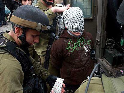 Soldados israelíes detienen a un palestino acusado de tirar piedras durante una manifestación en Hebrón.