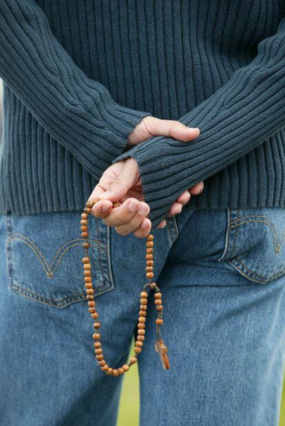 Un hombre joven con un rosario en la mano durante una acto religioso en Colonia, Alemania.