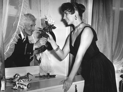 La actriz británica Joan Collins en Londres, en 1955, recibiendo flores de un viejo admirador en su apartamento.