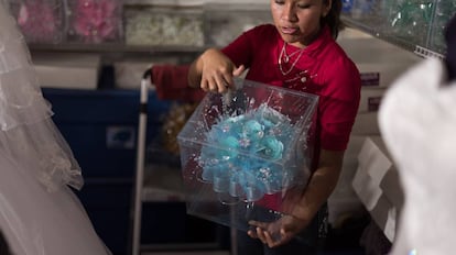 Una vendedora muestra uno de los ramos para quinceañeras.