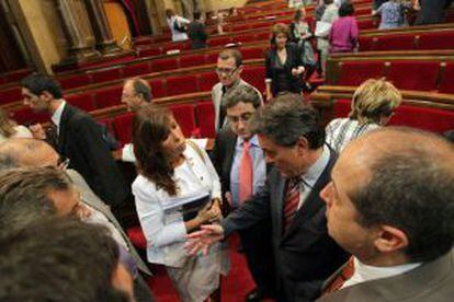 Alicia Sánchez-Camacho (PP) junto a Felip Puig en primer plano conversa con Artur Mas en un receso en el Parlament.