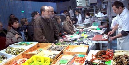 Varias personas compran en un mercado de Bilbao.