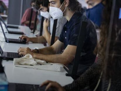 Jóvenes trabajando con ordenadores portátiles durante la pandemia de la Covid-19