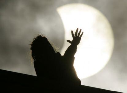 Una mujer observa el eclipse en San Petersburgo, Rusia.