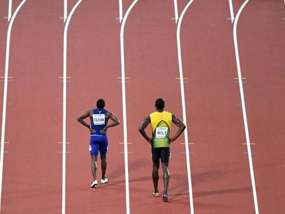 El norteamericano Cristian Coleman (i) y el jamaicano Usain Bolt caminan por la pista tras final de los 100 metros de los mundiales de atletismo de Londres.