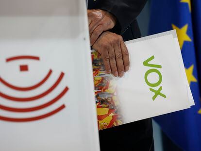 Ángel Pelayo Gordillo, el líder de Vox en Extremadura, sostiene una carpeta durante la presentación de acuerdo de gobierno entre su partido y Vox.