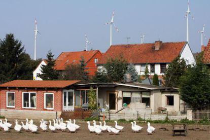 Los molinos de energ&iacute;a e&oacute;lica se ven tras los tejados de la localidad alemana Dardesheim.