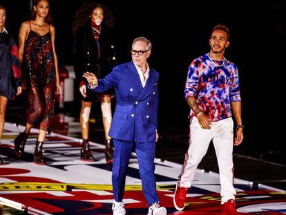 Tommy Hilfiger y Lewis Hamilton saludan tras acabar su desfile en Shanghái, China, el 4 de septiembre.