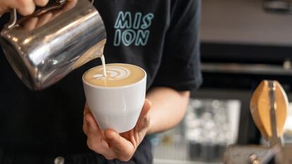 Un barista realiza 'latte art' sobre un café recién elaborado en Misión Café, en Madrid.