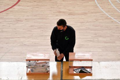 Un trabajador junto a dos urnas en el dispositivo electoral para los comicios catalanes de este domingo, en Barcelona.