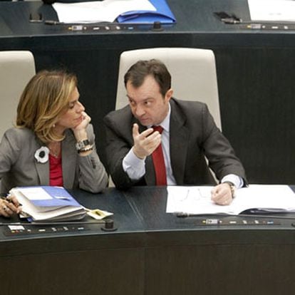 Ana Botella y Manuel Cobo charlan durante el pleno municipal celebrado ayer en Madrid.