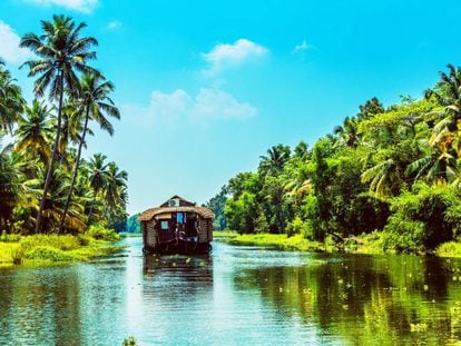 Un barco-vivienda atraviesa uno de los canales navegables del Estado de Kerala, al sur de la India.