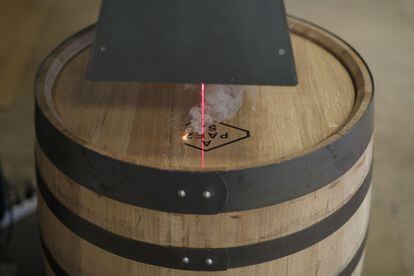 Un láser dibuja el logo de la empresa quemando la madera de un barril.