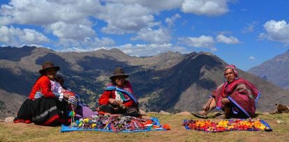 Miembros de la comunidad de Viacha, en el Valle Sagrado de Perú, muestran distintos tipos de papas y artesanías.
