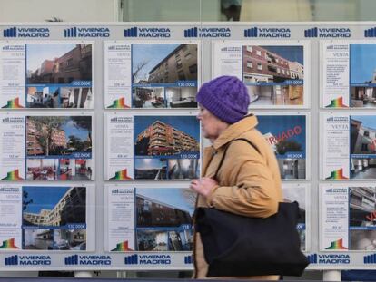 Una mujer pasa por delante de una inmobiliaria.