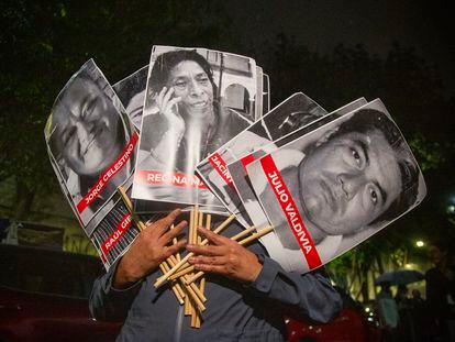 Una manifestante lleva las fotografías de periodistas asesinados o desaparecidos, el 10 de julio en Ciudad de México.