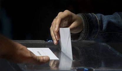 Un votante de Madrid introduce en la urna su voto.
