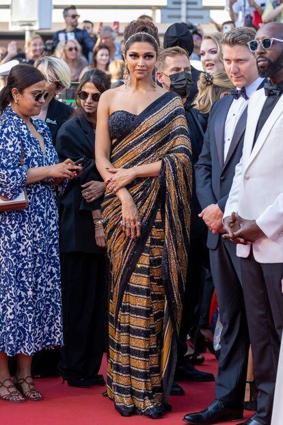 Deepika Padukone optó por un elegante sari de rayas y lentejuelas en negro y dorado del diseñador indio Sabyasachi, acompañado de una diadema dorada con pedrería y pendientes a juego.