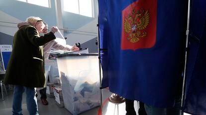 Una mujer deposita las papeletas de votación en un colegio electoral de San Petersburgo, este domingo.