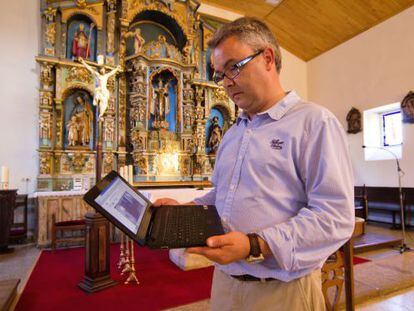 El párroco Rodrigo Rúa revisa su equipo de vigilancia por Internet.