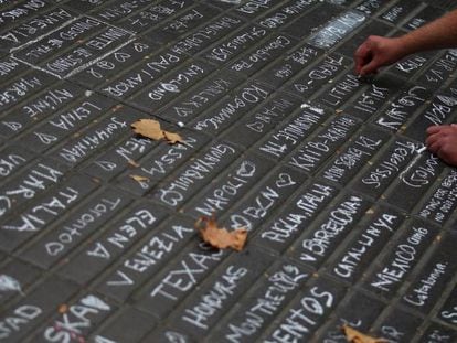 Cientos de turistas apuntan los países a los que pertenecen en el suelo de La Rambla, en solidaridad con los fallecidos en el atentado de Barcelona.