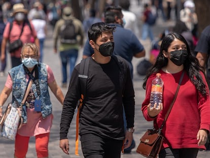 Fotografía de archivo que muestra a personas mientras caminan con mascarillas por una calle del centro histórico de Ciudad de México.